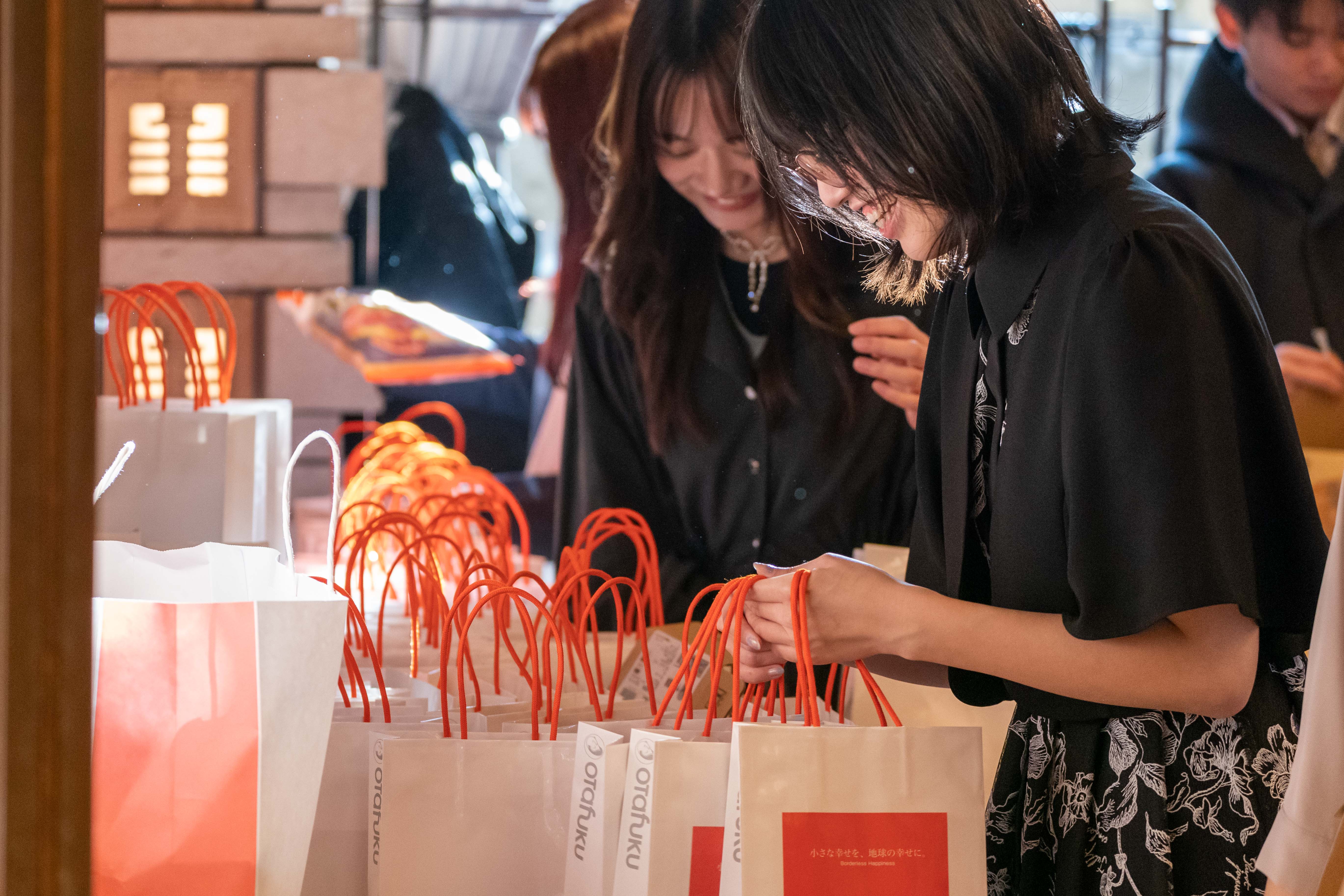 協賛グッズの入った紙袋を受け取るパーティー参加者